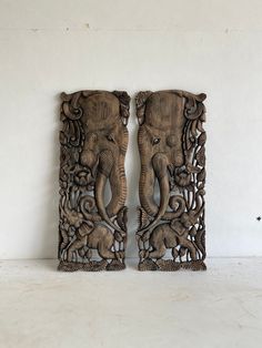 two carved wooden elephants standing next to each other