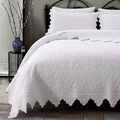 a bed with white sheets and pillows in a room