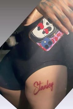 a woman with tattoos on her stomach holding onto a cell phone case that says stanley