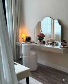 a white chair sitting in front of a desk with a mirror on it