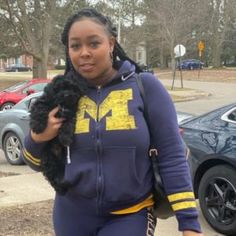 a woman is walking down the street with her hand in her pocket and wearing a hoodie