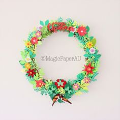 a paper wreath with flowers and birds on it