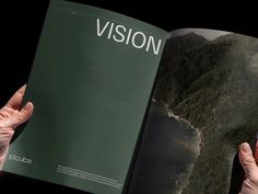 two hands holding an open book in front of a black background with the words vision on it