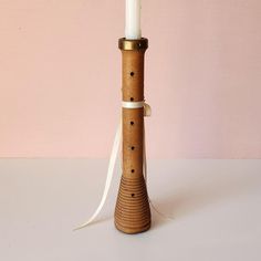 a wooden candle holder with a white ribbon around it