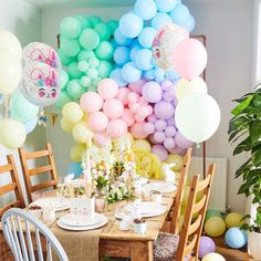 a dining room table with balloons and plates on it