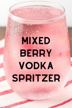 a pink drink in a glass with the words mixed berry vodka spritzer on it