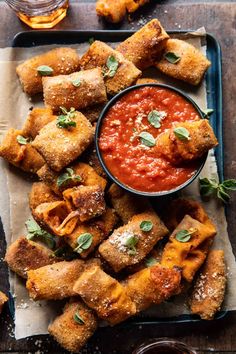 some food is on a tray and ready to be eaten with sauce in the bowl