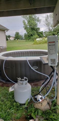 an inflatable hot tub and water pump sitting on the ground next to a house