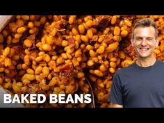 a man standing in front of a bowl of baked beans with bacon on the side