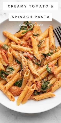 a white bowl filled with pasta and spinach