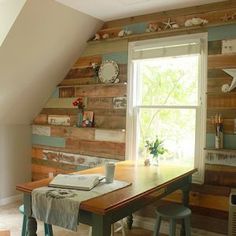 a room with a table and some chairs in front of a window that has wooden planks on the wall