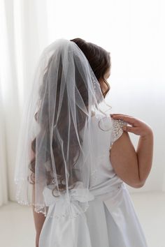 the back of a bride's veil as she adjusts her dress