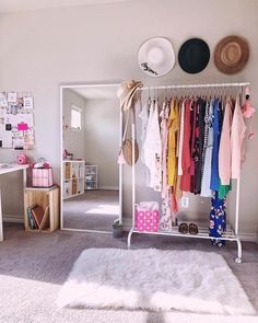 a room filled with lots of clothes and hats hanging on the wall next to a white rug