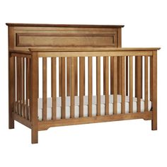 a wooden crib with white sheets on the bottom and side rails, against a white background