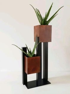 two wooden planters with plants in them sitting on top of black metal stand holders