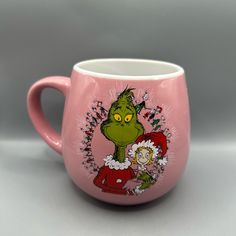 a pink coffee mug with the grin on it