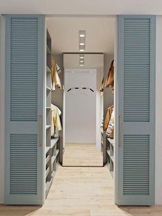 an open door leading to a bedroom with blue shutters on the walls and wooden flooring