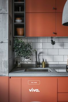 a kitchen with orange cabinets and white tile backsplash, an overhead light above the sink