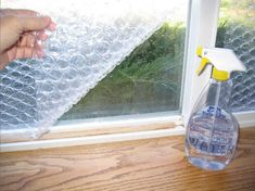 someone is holding a spray bottle near a window with the words bubble wrap insulation on it