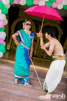 a man holding an umbrella standing next to a woman on steps with balloons in the background