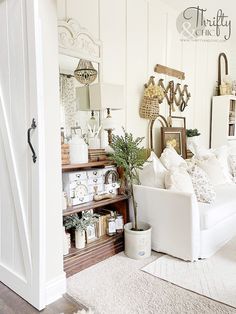 a living room filled with white furniture and lots of decor on top of it's walls