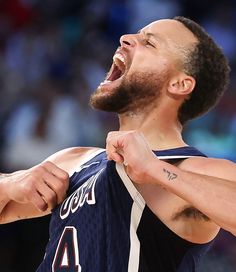 a basketball player holding his shirt open and laughing