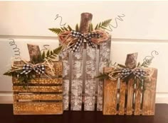 three wooden boxes with bows on them sitting on top of a table next to each other