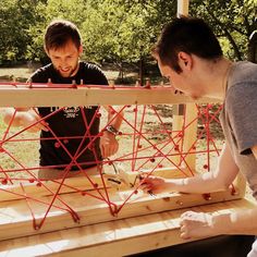 two men are working on an outdoor structure