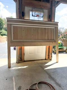 a garage with a basketball hoop in the middle of it and a hose laying on the ground