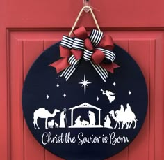 a christmas door hanger with a nativity scene on it and the words christ the savios born