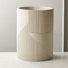 a white vase sitting on top of a table