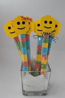 two yellow smiley face paper straws in a glass vase with tissue paper on the side