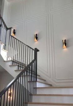 two lights are on the wall above some stairs