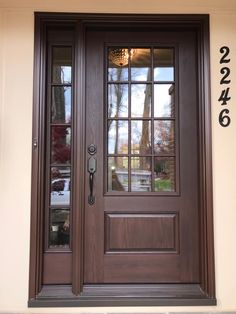 the front door is brown and has two sidelights on each side with glass panels