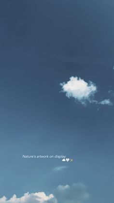 there is a plane flying in the sky with clouds above it and an inscription on the side