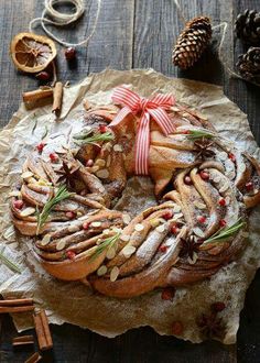 an apple cinnamon roll is on a piece of wax paper and surrounded by christmas decorations