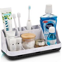 a white tray filled with toothbrushes and other hygiene products