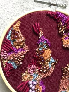 a close up of a embroidery on a piece of cloth with beads and bead work