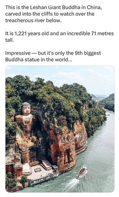 a boat traveling down a river next to a large statue on top of a cliff