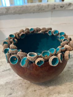 a brown bowl with blue flowers in it