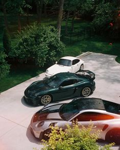 three sports cars parked next to each other on a driveway