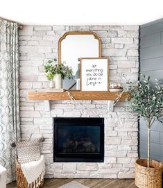 a living room with a fireplace, mirror and potted plants on the mantel