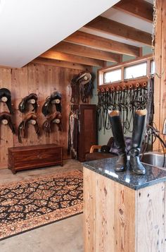 the inside of a horse stable with boots hanging on the wall