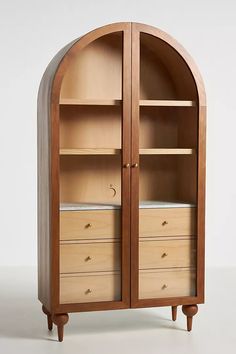 an arched wooden cabinet with drawers on both sides