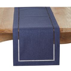 a blue table runner with white stitching on the edge and a wooden bench in the background