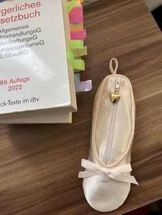 a white bag sitting on top of a wooden table next to a box with a gold heart