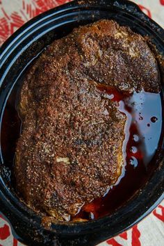 a close up of a food in a pan on a table with a red and white cloth