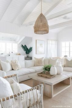 a living room filled with white furniture and pillows