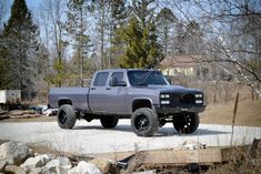 a gray truck parked on top of a gravel road