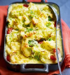 a casserole dish with broccoli and tomatoes